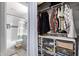 Well-organized closet showcasing hanging clothes, wire baskets, and a modern bathroom with a tiled shower in the background at 6604 W Kingston Ln, Glendale, AZ 85306