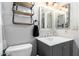 Stylish bathroom featuring a modern vanity with a sleek countertop, a framed mirror, and decorative shelves at 6604 W Kingston Ln, Glendale, AZ 85306