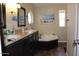Bright bathroom featuring a garden tub, double sink vanity, and decorative wall art at 7807 E Main St # D-32, Mesa, AZ 85207