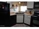 Kitchen area with a black dishwasher and stove, with a stainless steel sink at 7807 E Main St # D-32, Mesa, AZ 85207
