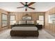 Cozy bedroom featuring wood paneling, a ceiling fan, and warm, neutral decor at 8103 E Southern Ave # 119, Mesa, AZ 85209