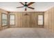Spacious bedroom with wood paneled walls, carpet flooring, and natural light from two windows at 8103 E Southern Ave # 119, Mesa, AZ 85209