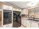 Classic kitchen featuring white cabinets, black appliances, and a mosaic tile backsplash at 8103 E Southern Ave # 119, Mesa, AZ 85209