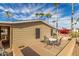 Relaxing outdoor patio with a table and four chairs, framed by palm trees and lush landscaping at 8103 E Southern Ave # 119, Mesa, AZ 85209