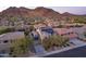 Aerial view of a desert landscape with a home featuring solar panels, beautiful mountain views, and a long driveway at 8362 W Rosewood Ln, Peoria, AZ 85383