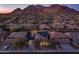 Stunning aerial view of a home with solar panels, mountain views, and desert landscaping at sunset at 8362 W Rosewood Ln, Peoria, AZ 85383