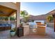 This outdoor kitchen area is perfect for entertaining with its built-in grill and ample counter space at 8362 W Rosewood Ln, Peoria, AZ 85383