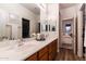 Bright bathroom featuring dual sinks, wood cabinets, and a view into the bedroom at 8362 W Rosewood Ln, Peoria, AZ 85383