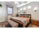 Bedroom with neutral tones featuring a large window with wooden blinds and sconce lighting at 8362 W Rosewood Ln, Peoria, AZ 85383