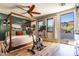 Bedroom featuring a four-poster bed, ceiling fan, and access to a patio with mountain views at 8362 W Rosewood Ln, Peoria, AZ 85383