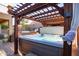 Relax in the hot tub under the pergola with a view of the built-in grill and fireplace in the backyard at 8362 W Rosewood Ln, Peoria, AZ 85383