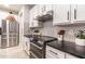Modern kitchen featuring stainless steel appliances, white cabinets, and a black tiled backsplash at 8362 W Rosewood Ln, Peoria, AZ 85383