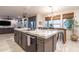 Bright kitchen featuring a large island with marble countertops, modern sink, and barstool seating at 8362 W Rosewood Ln, Peoria, AZ 85383