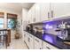 Stylish kitchen with white cabinets, black countertops, and a backsplash, creating a modern design at 8362 W Rosewood Ln, Peoria, AZ 85383