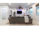 Cozy living room with a large gray sofa, ceiling fan, and natural lighting at 8362 W Rosewood Ln, Peoria, AZ 85383