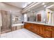 Luxurious bathroom with a soaking tub, walk-in shower, dual vanities, and designer fixtures at 9671 E Cavalry Dr, Scottsdale, AZ 85262