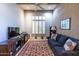Comfortable living room area with a cozy sofa, wooden beams, and plantation shutters at 9671 E Cavalry Dr, Scottsdale, AZ 85262