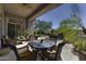 Beautiful covered patio with seating, overlooking lush landscaping and pool at 9671 E Cavalry Dr, Scottsdale, AZ 85262