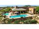 Community pool with lounge chairs and umbrellas surrounded by desert landscape at 9671 E Cavalry Dr, Scottsdale, AZ 85262