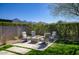 Backyard fire pit with patio seating, lush lawn, and desert mountain views at 9671 E West View Dr, Scottsdale, AZ 85255