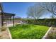 Lush backyard featuring manicured lawn, outdoor kitchen, pergola, and mountain views at 9671 E West View Dr, Scottsdale, AZ 85255