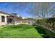 Expansive backyard featuring a lush lawn, covered patio, outdoor kitchen, and relaxing fire pit area, perfect for entertaining at 9671 E West View Dr, Scottsdale, AZ 85255