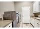 Efficient laundry room with modern washer and dryer, ample counter space, and storage cabinets for convenience at 9671 E West View Dr, Scottsdale, AZ 85255