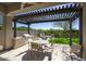 Inviting covered patio boasts an outdoor kitchen, dining area, and cozy seating around a fire pit with beautiful landscaping at 9671 E West View Dr, Scottsdale, AZ 85255