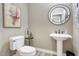 Charming powder room featuring a pedestal sink, decorative mirror, and floral artwork creating a cozy ambiance at 9671 E West View Dr, Scottsdale, AZ 85255