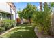 Landscaped backyard featuring an outdoor wooden gate, artificial turf, and mature foliage at 10076 E Calle De Cielo E Cir, Scottsdale, AZ 85258
