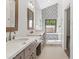Bright bathroom featuring double sinks, decorative mirrors, and stylish tile surrounding a picture window at 10076 E Calle De Cielo E Cir, Scottsdale, AZ 85258