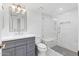 Updated bathroom featuring a marble shower with bench and a grey vanity with chrome fixtures at 10076 E Calle De Cielo E Cir, Scottsdale, AZ 85258