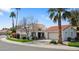 Inviting desert home with a red tile roof, green lawn, palm trees, and a circular driveway at 10076 E Calle De Cielo E Cir, Scottsdale, AZ 85258