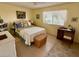 Cozy bedroom with a bright window, ceiling fan, and a comfortable bed with patterned pillows at 10323 W Deanne Dr, Sun City, AZ 85351