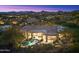 Night aerial view of luxurious home, backyard pool, outdoor patio and mountain views at 10379 E White Feather Ln, Scottsdale, AZ 85262