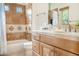A bathroom featuring light tile, wooden cabinets, updated finishes, and a separate tub and shower combo at 10379 E White Feather Ln, Scottsdale, AZ 85262