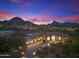 Stunning desert home featuring beautiful stone driveway, three-car garage and mountain views at sunset at 10379 E White Feather Ln, Scottsdale, AZ 85262