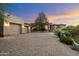 Charming home with a stone driveway, three-car garage, and lush landscaping at 10379 E White Feather Ln, Scottsdale, AZ 85262