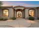 Elegant home featuring a beautifully arched entryway with stone accents at 10379 E White Feather Ln, Scottsdale, AZ 85262