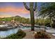Backyard pool surrounded by desert landscaping, rocks, a waterfall, and built-in grill at 10379 E White Feather Ln, Scottsdale, AZ 85262