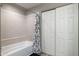 Bathroom featuring tiled shower, curtain, and closet with sliding doors at 10410 N Cave Creek Rd # 2114, Phoenix, AZ 85020