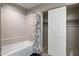 Bathroom featuring tiled shower, curtain, and closet with sliding doors at 10410 N Cave Creek Rd # 2114, Phoenix, AZ 85020