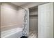 Bathroom featuring tiled shower, curtain, and closet with sliding doors at 10410 N Cave Creek Rd # 2114, Phoenix, AZ 85020