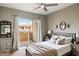 Cozy bedroom features neutral decor, ceiling fan and sliding glass door with access to an outdoor balcony at 10410 N Cave Creek Rd # 2114, Phoenix, AZ 85020