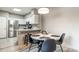 Dining area with a modern light fixture, round table, and view of the kitchen at 10410 N Cave Creek Rd # 2114, Phoenix, AZ 85020