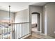 Upstairs hallway and loft area with railing, arched window and bedroom access at 10410 N Cave Creek Rd # 2114, Phoenix, AZ 85020