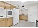 Bright kitchen with light wood cabinetry, white refrigerator and tile floors at 10414 N 105Th Ave, Sun City, AZ 85351
