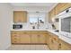Well-lit kitchen featuring light wood cabinets, white countertops, and stainless steel appliances at 10414 N 105Th Ave, Sun City, AZ 85351