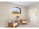 Cozy living room with stylish seating and a large arched window framing mountain views at 10917 E Raintree Dr, Scottsdale, AZ 85255