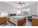 Bedroom features a wood frame bed, ceiling fan, and natural light from the window at 11034 E Natal Ave, Mesa, AZ 85209